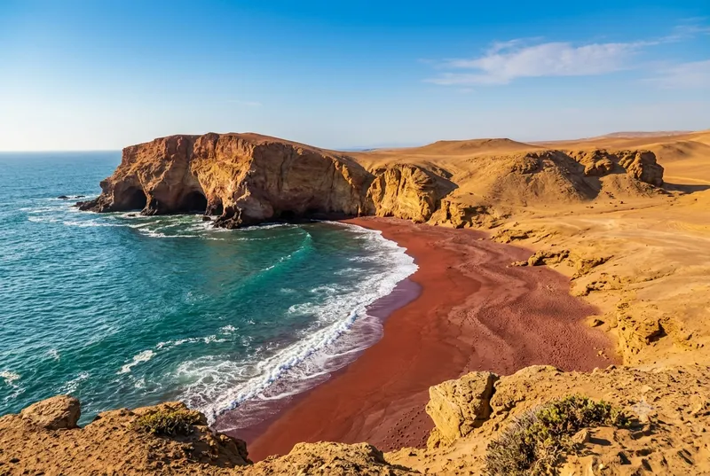 Paracas Red Beach — dramatic crimson sand and turquoise water inside the Paracas National Reserve